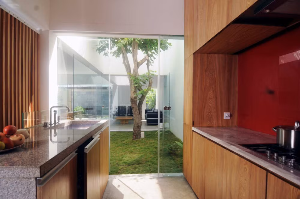 Không gian bếp kết nối với sân nhỏ trồng cây xanh.