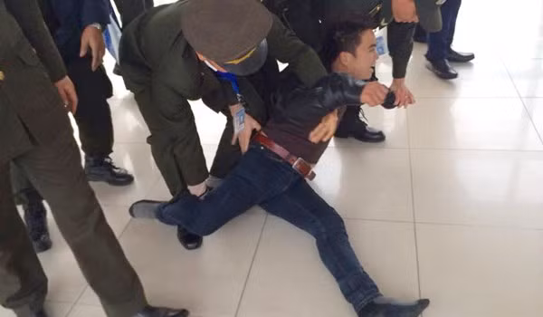 Lực lượng an ninh sân bay Nội Bài phải rất vất vả mới khống chế và đưa nam thanh niên ngáo đá rời khỏi khu vực làm thủ tục check in. (Ảnh: otofun).