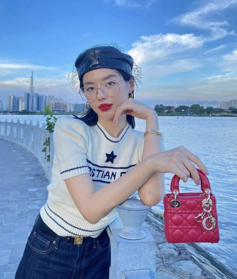 Cô Em Trendy" Khánh Linh cổ điển hơn khi kết hợp thêm phụ kiện mũ nồi Dior và túi Lady Dior màu đỏ làm điểm nhấn cho outfit thêm mãn nhãn.