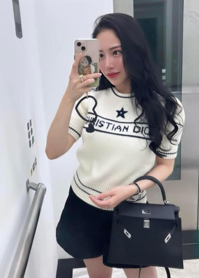 oyce Phạm khoe outfit ra phố trông đơn giản nhưng có tổng giá đến nửa tỷ đồng. Bà mẹ hai con mặc áo len ngắn tay của Dior kết hợp túi xách Hermes Kelly và vòng tay cùng thương hiệu. Trang phục tông đen trắng giúp con gái Minh "Nhựa" tôn dáng thon gọn dù mới sinh bé thứ hai cách đây không lâu.