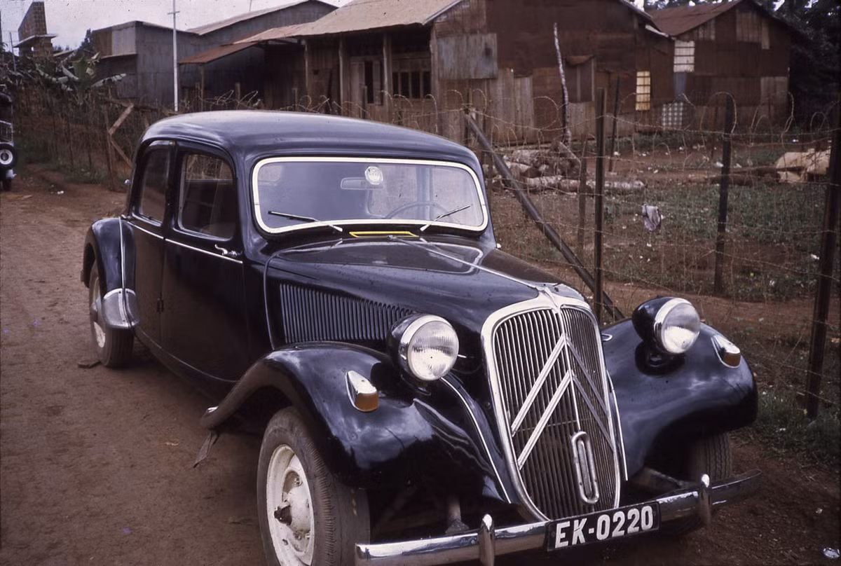 Chiếc xe bên ngoài một khu dân cư tồi tàn..