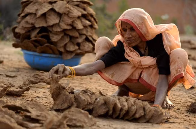 Người làm sẽ thu lượm phân bò rồi trộn với cỏ khô làm thành hình như quả bóng rồi đập chúng vào một bức tường và dùng tay trần để ấn bàn tay lên chiếc bánh.