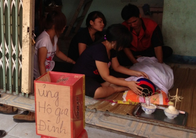 Vợ chồng anh Huy đau đớn ngồi ôm xác con than khóc.