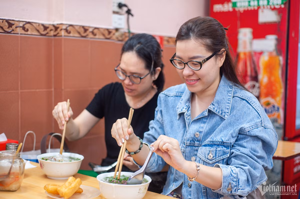 Chị Trần Thị Việt Hải (áo bò) là khách quen tại quán đã 7-8 năm nay do mê phần nước dùng ngọt, đậm đà, thơm mùi xương. Chị Hải thật lòng chia sẻ: "Quán lúc nào cũng đông nên ngày nào vội, tôi không dám ghé, sợ chờ lâu. Nhưng hễ rảnh tôi sẽ qua thưởng thức". Nữ thực khách khá bất ngờ khi nhìn thấy chứng nhận Michelin được treo trang trọng tại quán. Chị Hải cho rằng, quán xứng đáng nhận danh hiệu này.