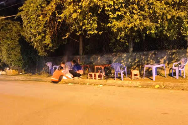 Đang ngồi uống chai trà xanh C2 của công ty TNHH URC Việt Nam ven vỉa hè trên đường, người đàn ông bất ngờ ngã bật ra sau tử vong. Ảnh: Vũ Sơn