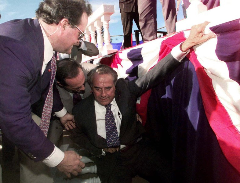 Ứng cử viên tổng thống đảng Cộng hòa Bob Dole được các nhân viên mật vụ đỡ dậy sau khi ông ngã khỏi sân khấu trong một cuộc vận động tranh cử ở Chico, bang California, ngày 18/9/1996.