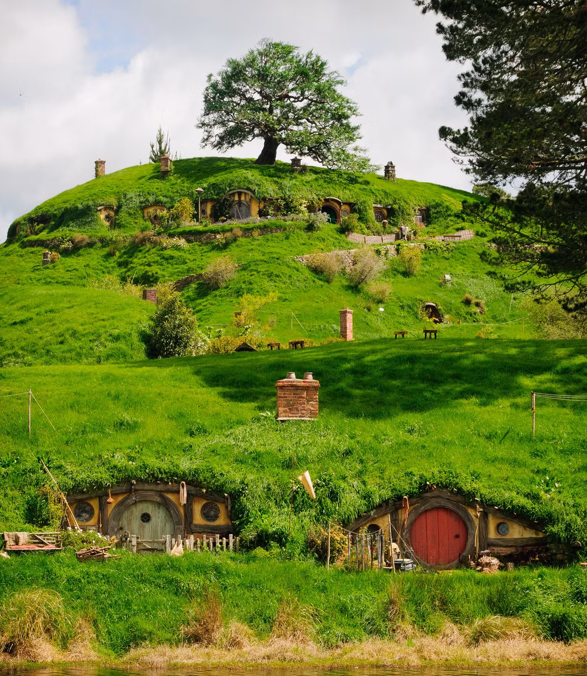 Nằm tại Matamata, Đảo Bắc, New Zealand, tiền thân của Hobbiton lừng danh là một bãi cỏ rộng 500ha, dùng để chăn thả 13.000 con cừu và 300 con bò. Vào năm 1998, trong khi đi tìm địa điểm quay loạt Lord of the Rings (Chúa tể của những chiếc nhẫn), đạo diễn Peter Jackson đã vô tình phát hiện ra và lập tức "chấm" nó.