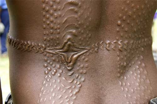 5. Rạch người: Ở bộ tộc bên dòng sông Sepik, Papua New Guinea, họ thực hiện nghi thức rạch người để đánh dấu sự trưởng thành của người đàn ông. Những người già trong bộ tộc sẽ dùng những lưỡi dao sắc bén để rạch nhiều đường ở lưng và mông các chàng trai trẻ, chà xát tro lên đó, khi da liền lại sẽ tạo thành những vết sẹo lồi như da cá sấu. Người dân Sepik tin rằng, con cá sấu sẽ hút hết tính trẻ con của chàng trai và họ sẽ trở thành người đàn ông.