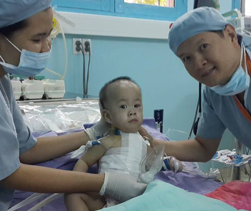 TS.BS Trương Quang Định, Phó giám đốc Bệnh viện Nhi đồng 2 TP.HCM hạnh phúc bên bé Phi Long sau khi cai máy thở.