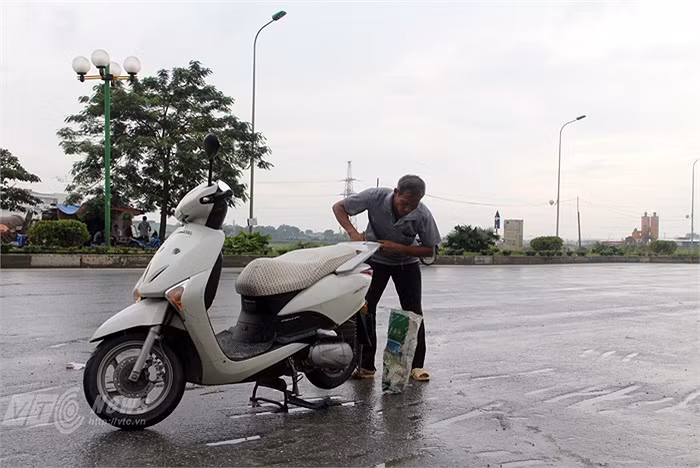 Cứ có xe máy cần vá xăm chú Định lại không nề hà dù trời vẫn đang mưa.
