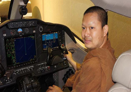 Sư Luang Pu Nen Kham Chattiko trên phi cơ riêng.