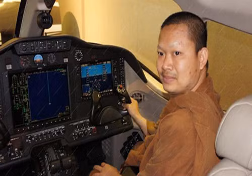 Sư Luang Pu Nen Kham Chattiko trên phi cơ riêng.