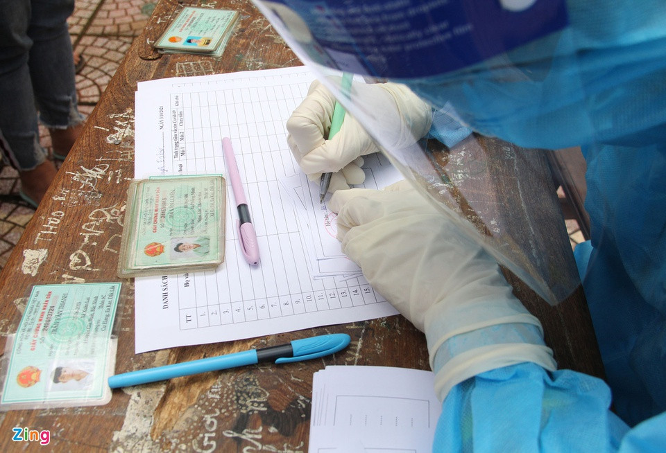 Tình nguyện viên ghi lại thông tin người dân để liên hệ các huyện đón công dân về sau khi hoàn thành xét nghiệm nhanh.