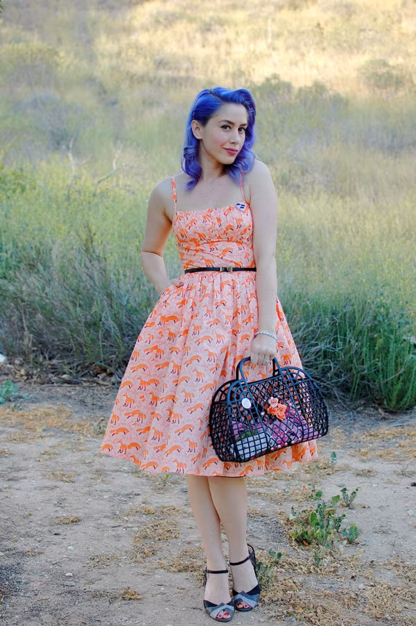 Vẫn con đường đất, cây cỏ bên đường và chiếc giỏ quen thuộc, cô gái trong ảnh tạo dáng chuyên nghiệp với màu tóc bắt mắt cùng áo họa tiết. Chiếc giỏ màu đen đã tiết chế bộ trang phục vốn nhiều màu sắc.