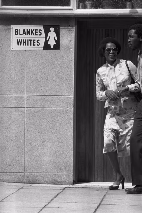 Người phụ nữ da đen đứng cạnh biển báo "chỉ dành cho phụ nữ da trắng" bằng hai thứ tiếng Anh và Afrikaans ở Johannesburg. Những tấm biển như vậy rất phổ biến ở Nam Phi dưới chế độ Apartheid. Ảnh: A. Abbas/ Magnum Photos.