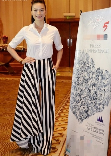 Ngô Thanh Vân diện mốt quần có một bên ống suông rộng như váy với họa tiết kẻ sọc giúp chân thêm dài.