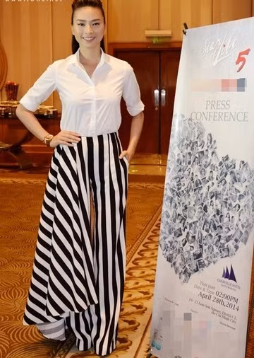 Ngô Thanh Vân diện mốt quần có một bên ống suông rộng như váy với họa tiết kẻ sọc giúp chân thêm dài.