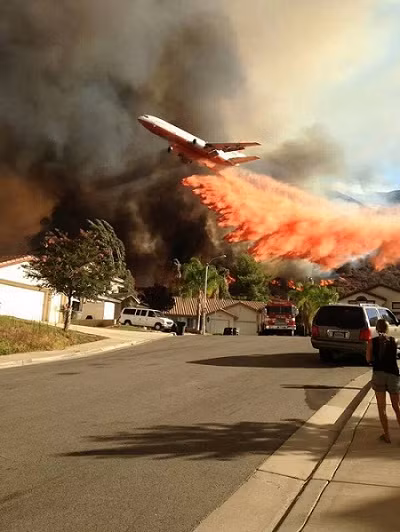 Máy bay chở dầu DC-10 bay qua đám cháy rừng và bay tiếp vào một khu dân cư của Los Angeles.