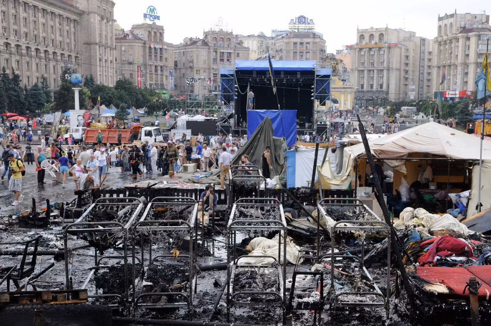 Người dân và nhân viên vệ sinh dọn dẹp các chướng ngại vật ở Quảng trường Maidan ngày 9/8/2014.