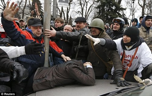 Những người biểu tình chống chính phủ đánh đạp một người ủng hộ Tổng thống Yanukovych.