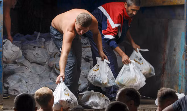 Những người tị nạn xếp hàng chờ lấy đồ viện trợ ở Mariupol.