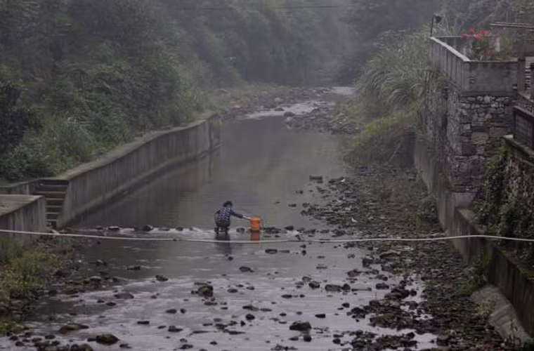 Cuộc sống nghèo nàn khiến người dân buộc phải sống chung với mối nguy hiểm cận kề. Bức ảnh ghi lại khoảnh khắc người dân giặt quần áo bằng nguồn nước sông ô nhiễm.