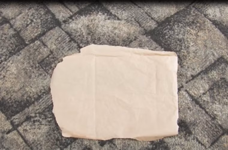 Nếu thảm vẫn còn dính nến, tiếp tục dùng một tờ giấy thấm có khả năng thấm sáp phủ lên.