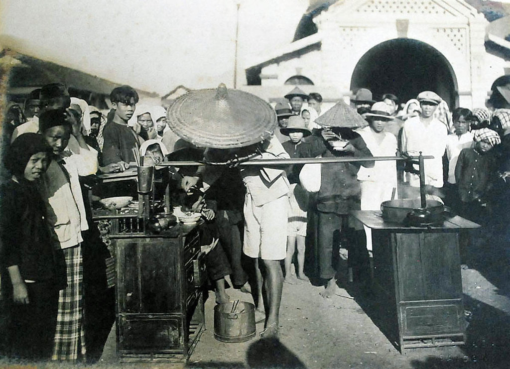 Một gánh hàng rong, có lẽ là hủ tiếu, chợ Gò Vấp khoảng năm 1930. Mặt tiền chợ hướng Tây - hậu chợ hướng Đông, xây thô sơ gồm 3 lều, mỗi lều cách nhau chục thước, chia thành các khu vực hàng hóa khác nhau..