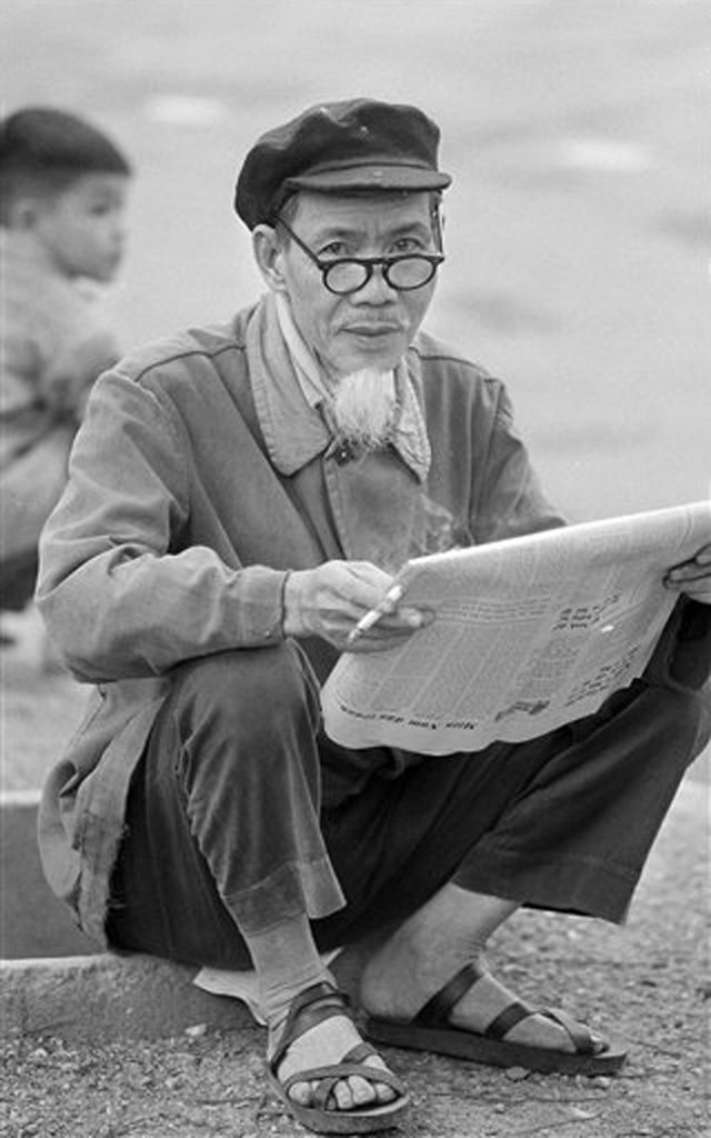 Cụ ông ngồi đọc báo trên vỉa hè, 5/4/1973.