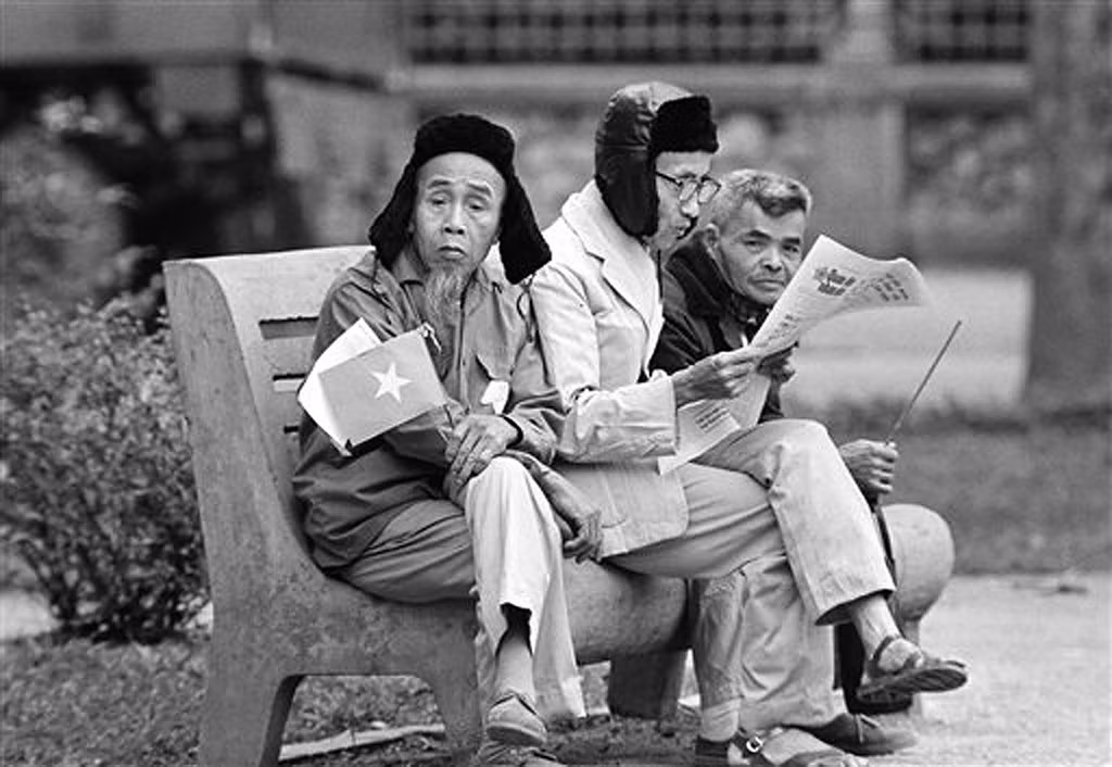 Các cụ ông đọc báo bên bờ hồ trong lúc chờ một phái đoàn nước ngoài đi qua để chào mừng, 5/4/1973.