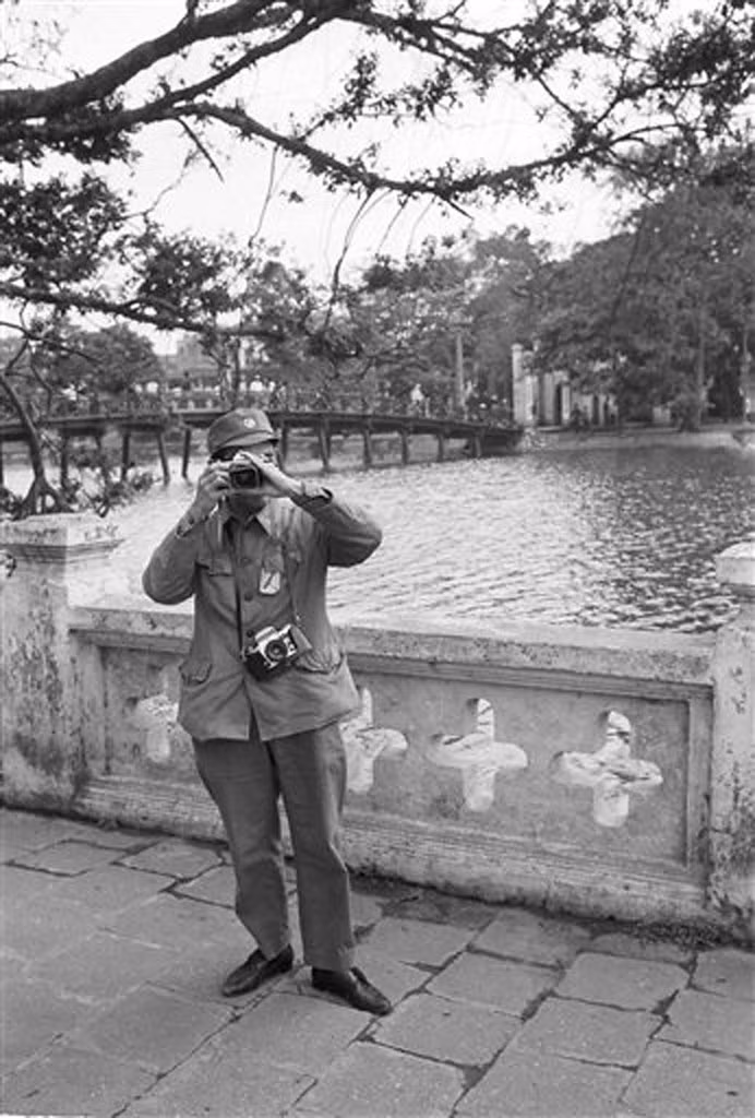 Khoảnh khắc hai phó nháy Việt - Mỹ chụp ảnh lẫn nhau ở bờ hồ Gươm, gần đền Ngọc Sơn, 29/3/1973. Người được chụp trong bức ảnh này có lẽ là một quân nhân yêu nhiếp ảnh với hai chiếc máy ảnh mang theo người. Thời điểm năm 1973, đoạn bờ hồ này có lan can bảo vệ.