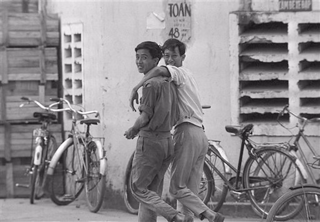 Hai nam giới khoác vai nhau đi trên phố, 17/3/1973.