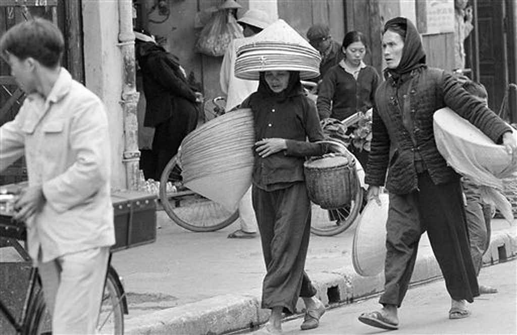 Cụ bá bán nón trên đường phố đông đúc ở khu vực chợ Đồng Xuân, 2/4/1973.
