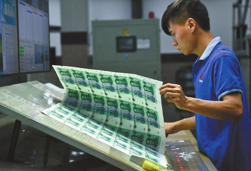 Một công nhân đang kiểm tra kỹ lỗi in trên sản phẩm.