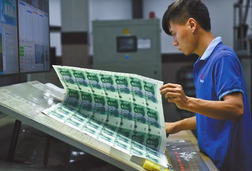 Một công nhân đang kiểm tra kỹ lỗi in trên sản phẩm.