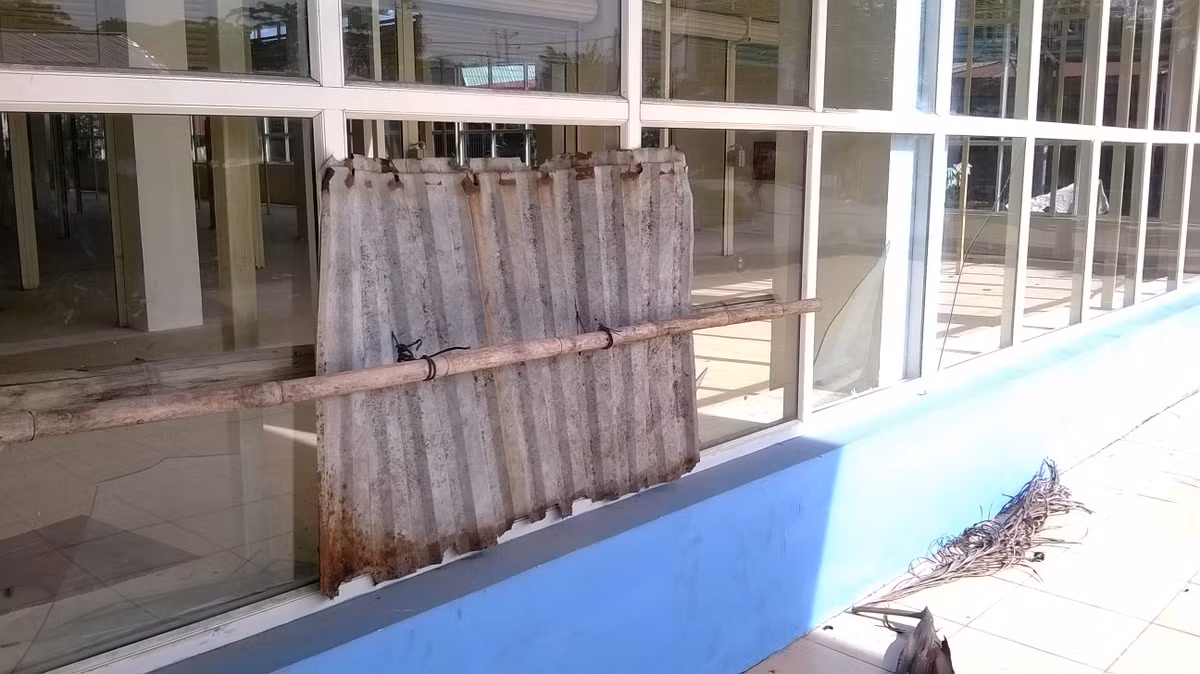 Ô kính đã bị vỡ phải gắn tạm bằng miếng tấm lợp đã rách.