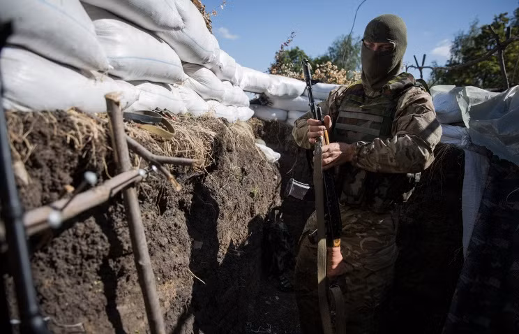 Một lính Ukraine đang đứng ở chiến hào đào ở tình Lugansk.