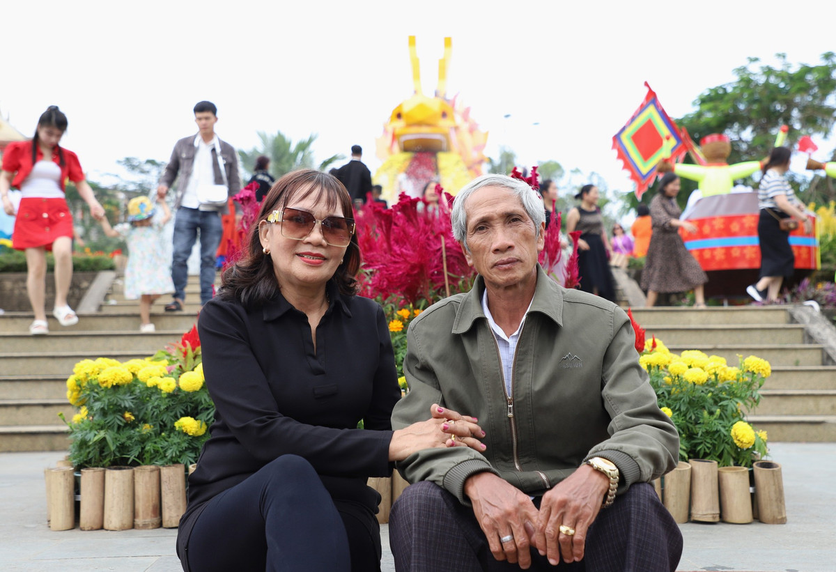 Người dân chụp ảnh lưu niệm với cảnh quan rực rỡ sắc màu Tết tại TP. Quảng Ngãi. Ảnh: Ngô Tùng