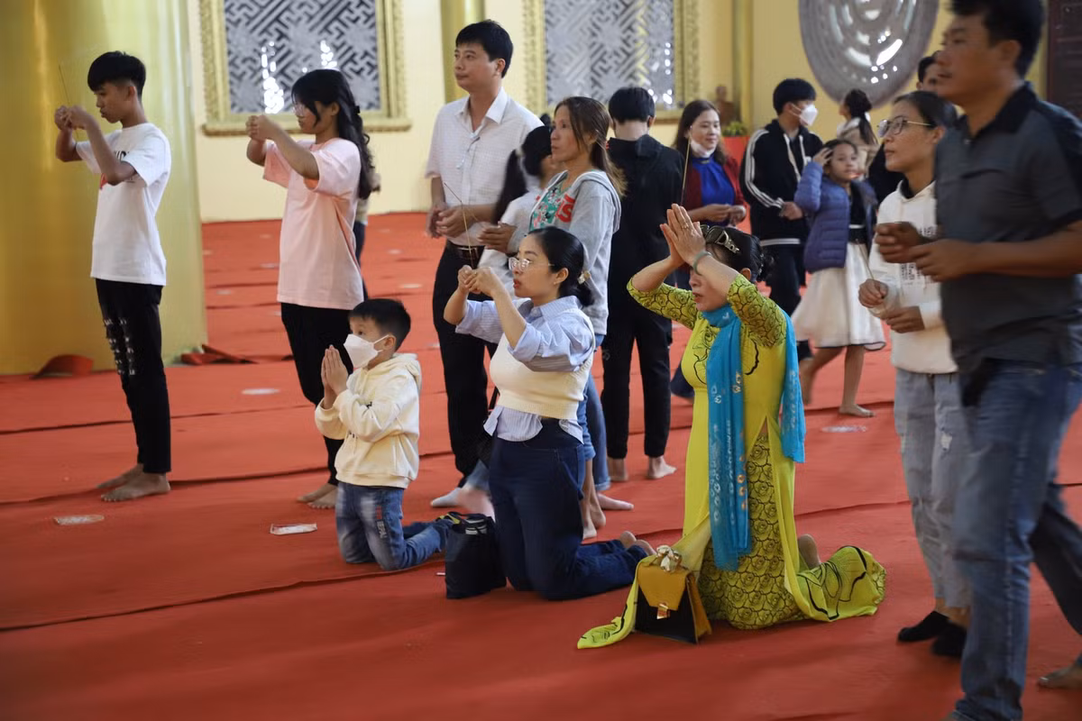Người lớn, em nhỏ thành kính thắp hương lễ Phật ngày Tết.