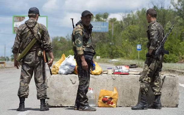 Dân quân tự vệ đứng canh gác ở một trạm kiểm soát ngoại ô thị trấn Metalist, phía bắc tỉnh Lugansk.