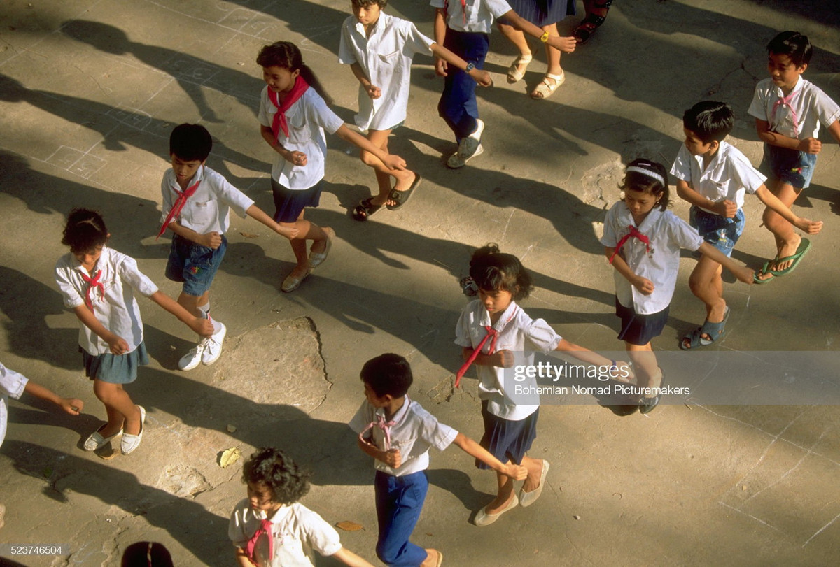 Học sinh tiểu học tập thể dục trên sân trường.