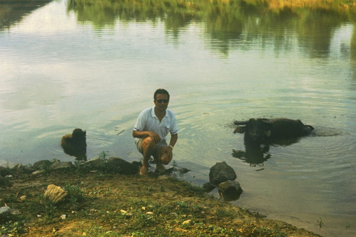 Ông Günter Mosler chụp ảnh lưu niệm bên một chú trâu đang đầm mình dưới nước.