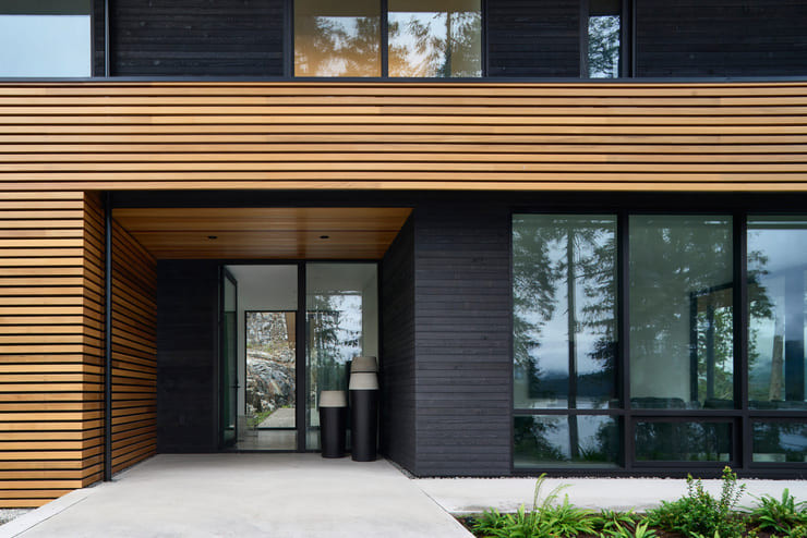 Một bảng màu vật liệu ngoại thất tối thiểu bao gồm vách ngăn bằng gỗ tuyết tùng và vải phủ bằng gỗ tuyết tùng mang lại sự ấm áp và kết cấu độc đáo, đồng thời liên kết tòa nhà với khu rừng tuyết tùng xung quanh.