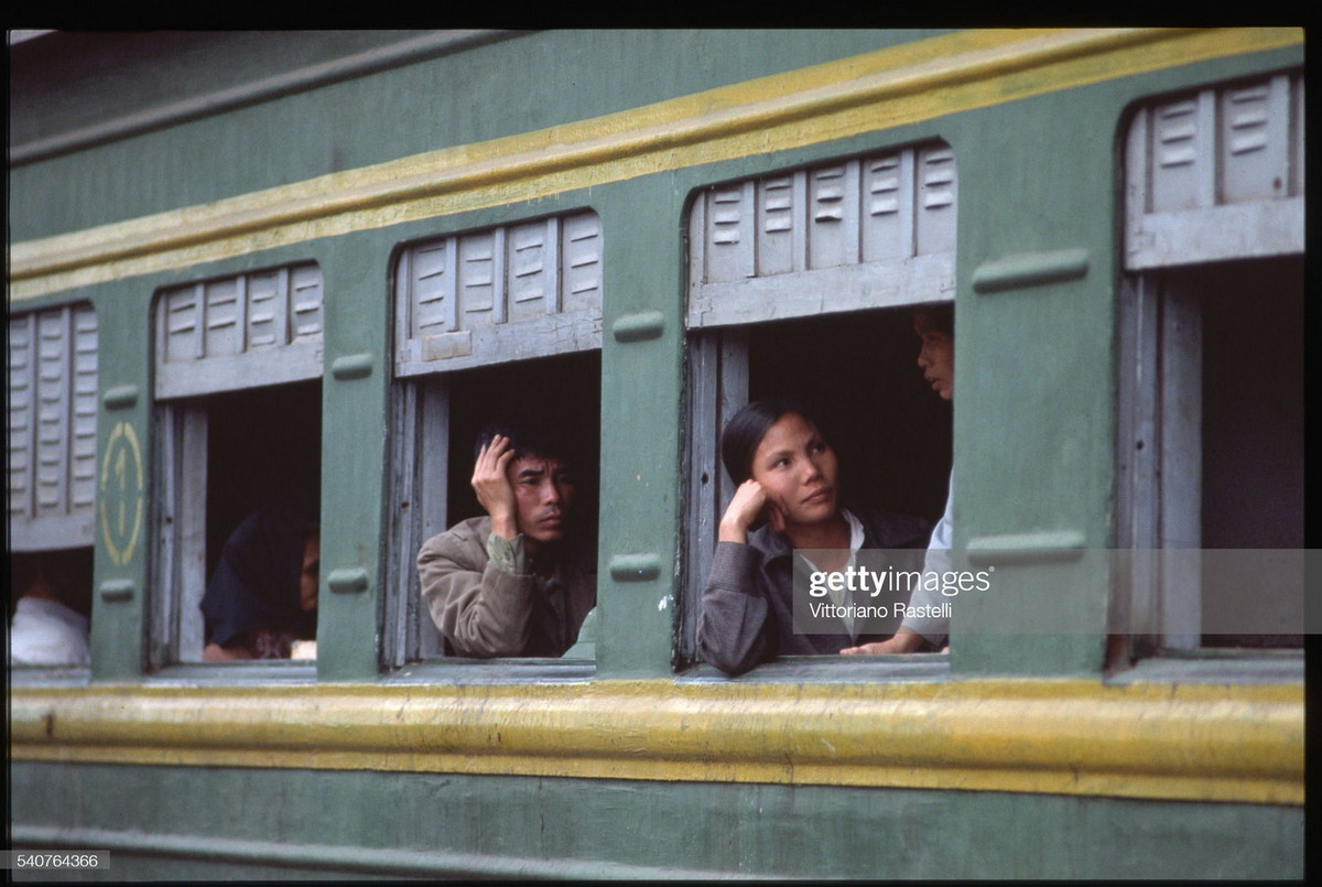 Các hành khách bên cửa sổ một toa tàu ở ga Hà Nội.