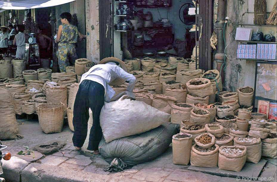 Cửa hàng bán thuốc Nam với các vị thuốc được chứa trong bao bày kín vỉa hè.