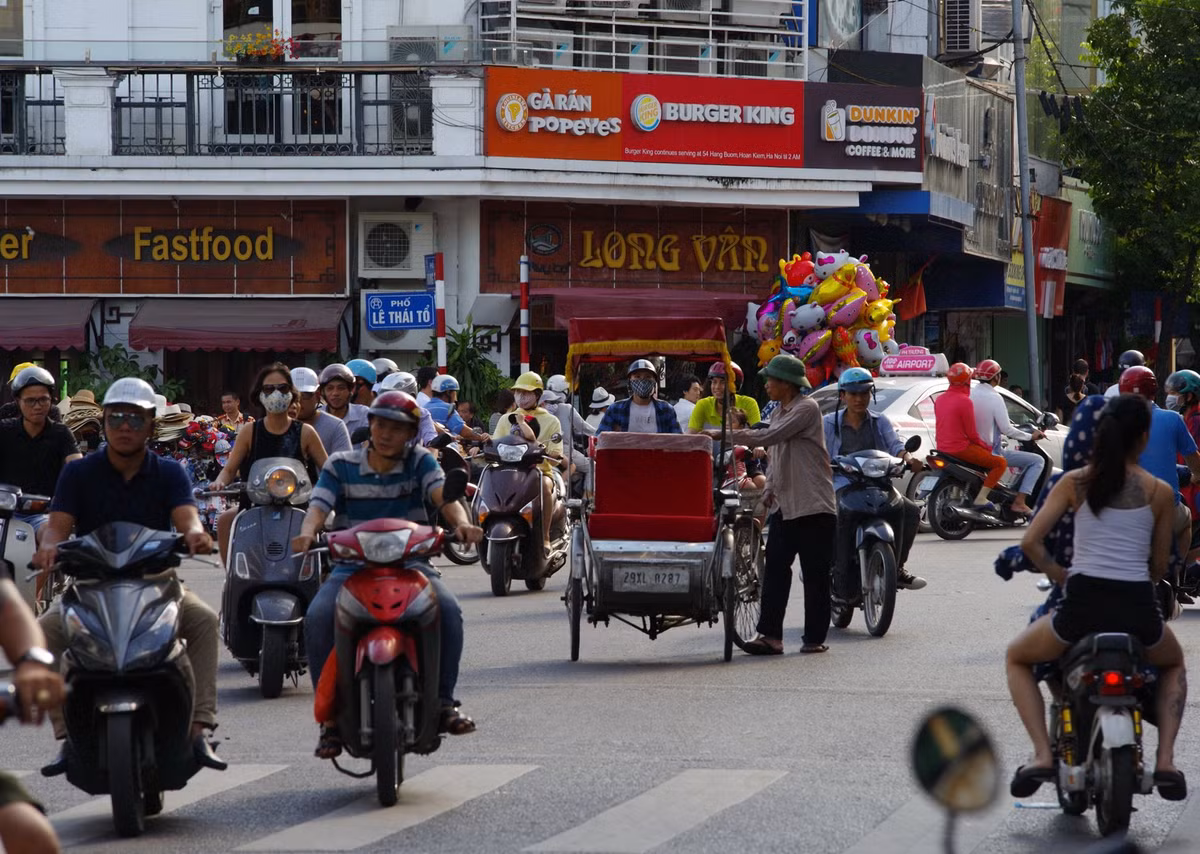 Một chiếc xích lô lạc lõng giữa biển xe cộ ở quảng trường Đông Kinh Nghĩa Thục, năm 2018. Hiện tại xích lô chỉ hoạt động hạn chế để phục vụ khách du lịch ở khu vực bờ hồ - phố cổ. Ảnh: Yuichi Kobayashi Facebook.