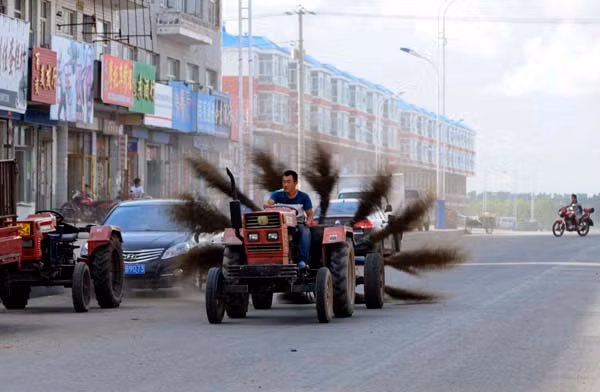 Một người đàn ông lái chiếc máy kéo được gắn 12 cái chổi ở bên rìa để quét sạch đường phố ở Mohe, tỉnh Heilongjiang Trung Quốc vào ngày 31/8/2013.