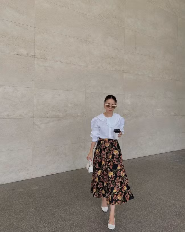 Yến Trang đã rất cao tay khi diện chân váy dài tối màu nhưng không hề bị "dừ". Bí kíp của nữ ca sĩ chính là mix chân váy với áo blouse trắng, túi xách, giày dép sáng màu.