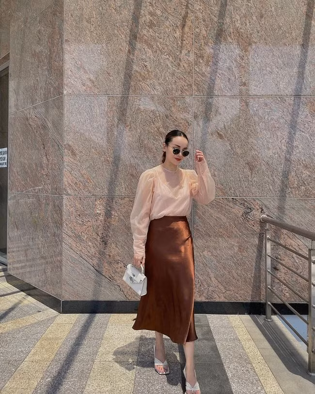 Với áo tay bồng, Yến Trang đã kết hợp với chân váy lụa để tạo nên set đồ siêu sang chảnh, mà vẫn đủ nhã nhặn, tinh tế. Đôi sandal dáng mule, thao tác sơ vin đã đem đến hiệu ứng hack dáng triệt để cho người mặc.