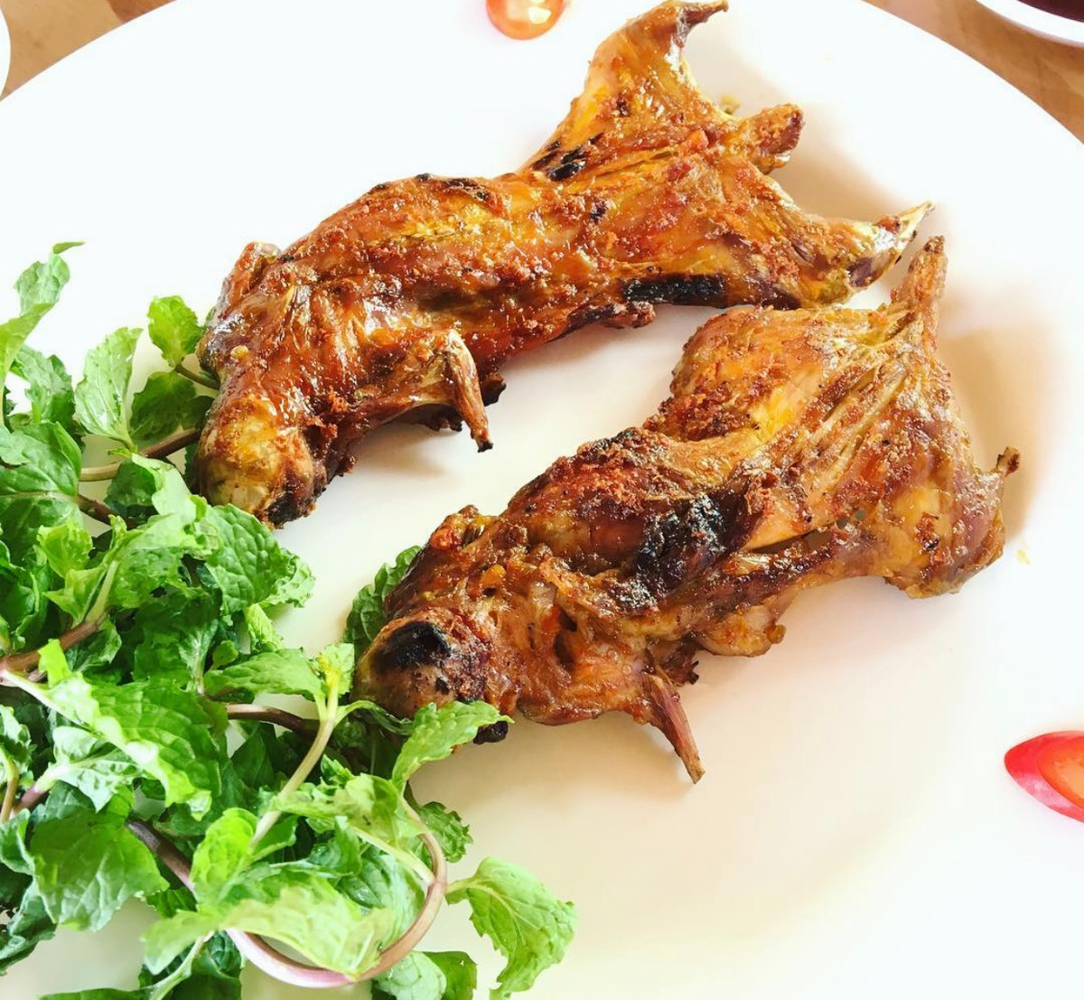 Ở miền Tây, chuột đồng được bán nhiều nhất khi tới vụ lúa. Chuột ăn no lúa chín nên con nào cũng mập, thịt thơm. Những con chuột được sơ chế kỹ, tẩm ướp tỏi, sả, muối, đường, bột ngọt, phết thêm mật ong cho hấp dẫn, sau đó móc vào lu nướng. Đặc sản đồng quê được dọn kèm dưa leo, chuối chát hoặc khế chua, cà chua cắt lát, muối tiêu chanh cùng rau răm. Không phải thực khách nào ghé miền Tây cũng dám thử món ăn này. Ảnh: Ginnyvo0806.